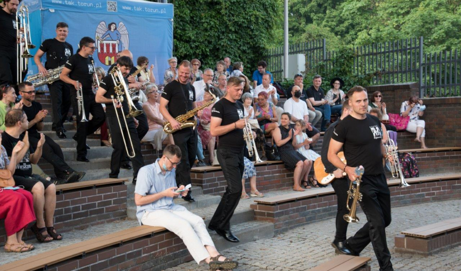 Muzycy z instrumentami schodzą po schodach amfiteatru w Baju Pomorskim