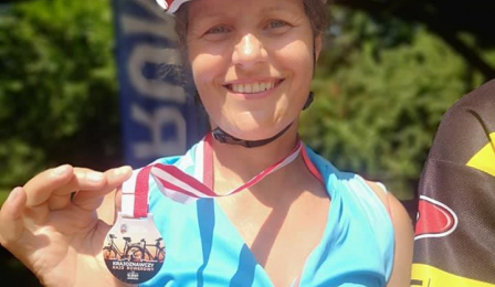 Na zdjęciu uczestniczka krajoznawczego rajdu rowerowego z pamiątkowym medalem
