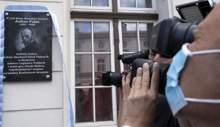 Na zdjęciu: tablica poświęcona Julianowi Fałatowi i obiektyw kamery
