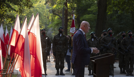 Przemawiający prezydent Torunia Michał Zaleski i flagi biało-czerwone
