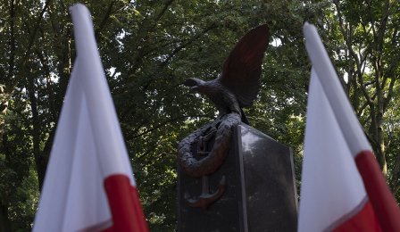 Pomnik i dwie flagi biało-czerwone po bokach