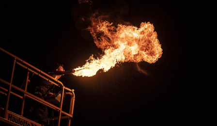 Na zdjęciu widać artystę, który wykonuje pokaz z ogniem