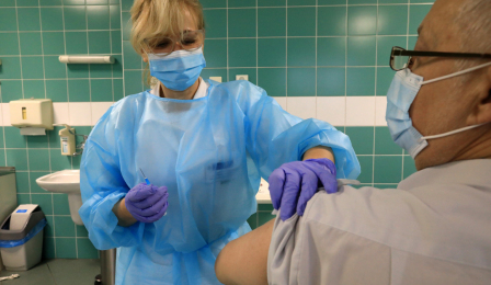 Pielęgniarka aplikuje szczepionkę w ramię pacjenta
