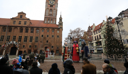 Figury trzech króli stoją na Rynku Staromiejskim, w tle ratusz staromiejski