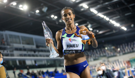 Lemlem Hailu po zwycięstwie w biegu na 3000 m pozuje do zdjęcia ze statuetką w ręku.