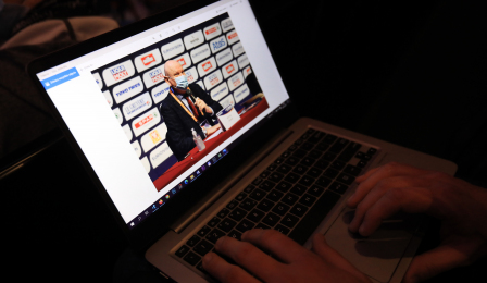 Dziennikarz ogląda na ekranie laptopa zdjęcie prezydenta Torunia z konferencji.