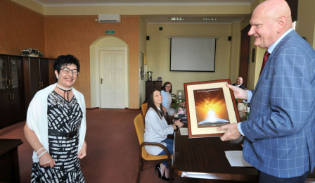 Prezydent odbiera pamiątkową grafikę od Elżbiety Łukasik