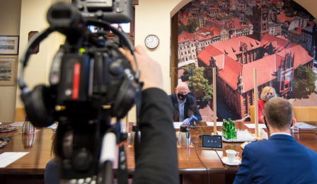 Prezydent Michał Zaleski przemawia do absolwentów, na pierwszym planie widac kamerę