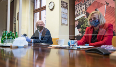 Prezydent Michał Zaleski i Elżbieta Kowalska, zastępca dyrektora Wydziału Gospodarki Nieruchomościami, siedzą przy stole, przed nimi ścianka plastikowa