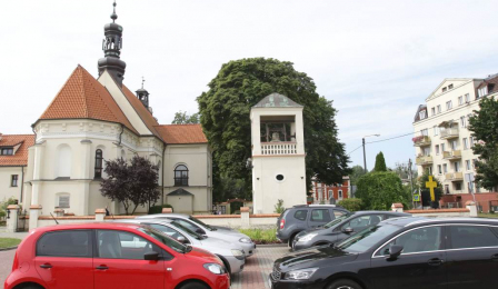 Na zdjęciu dzwonnica i kościół pw. Świętych Apostołów Piotra i Pawła na Podgórzu. Widać też samochody zaparkowane przed bramą