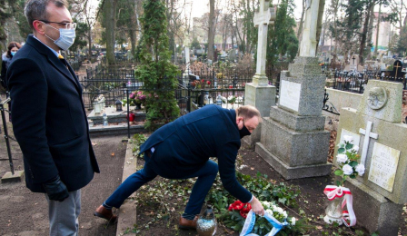 Zastępca prezydenta Paweł Gulewski pochyla się nad grobem Wandy Szuman, składając kwiaty, obok stoi przewodniczący Rady Miasta Torunia Marcin Czyżniewski